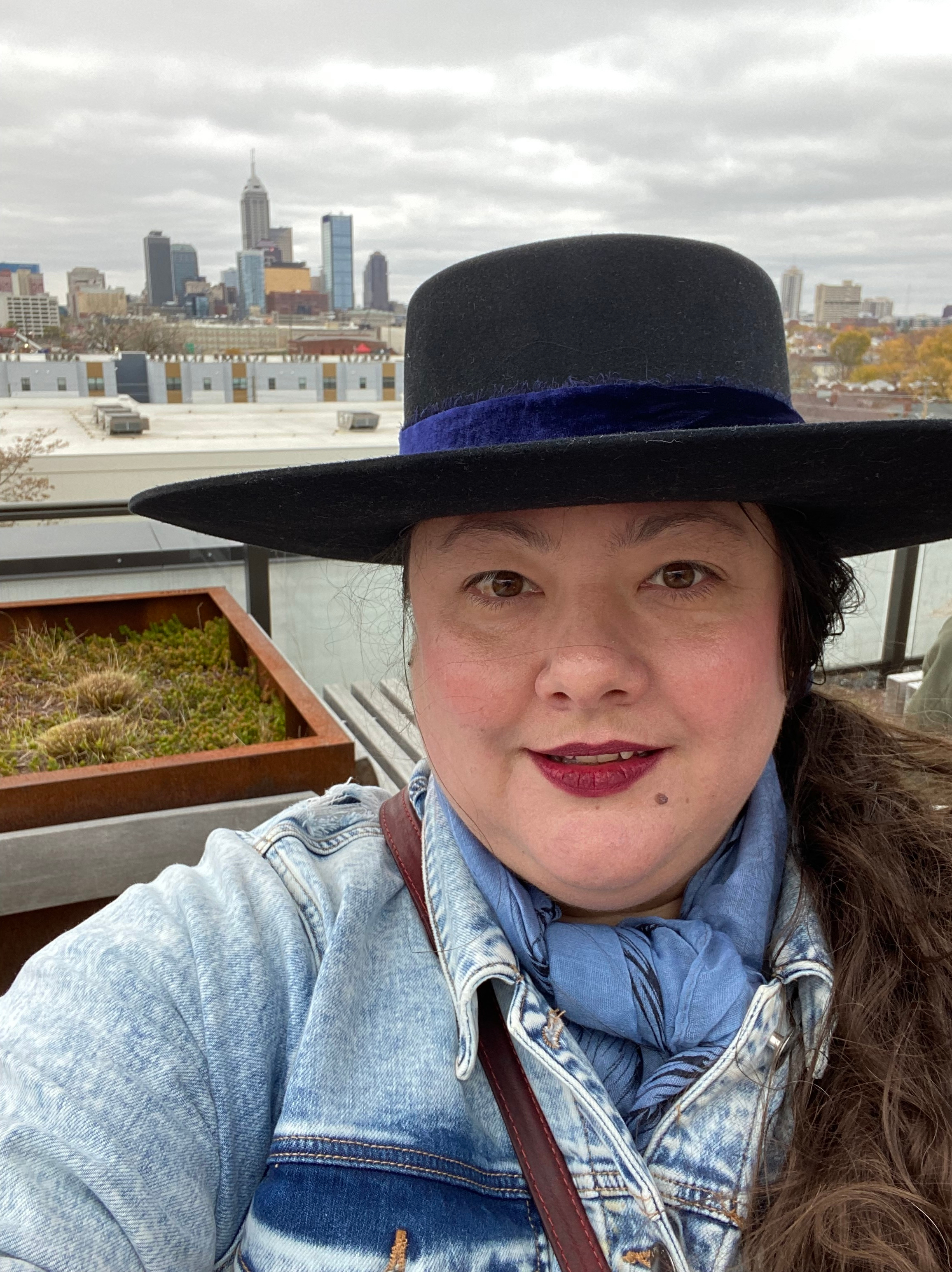 Rachel Sahaidachny in a black hat with the Indianapolis city scape behind her